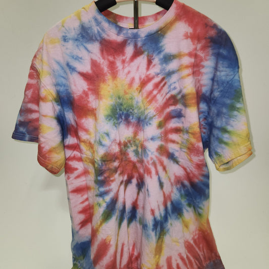 Colorful tie-dye shirt on a wooden hanger against a plain background